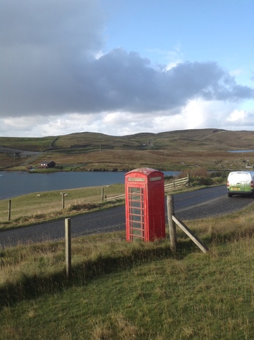 The phone box as it's positioned near the road.